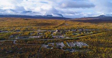 Aerial drone view of the Abisko town, in middle of foliage nature, on a sunny autumn day, in Lappland, Norrbotten, Sweden clipart