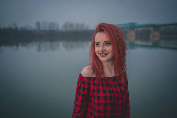 ぼやけた川の前に赤い髪の若い女性の肖像画 — ストック写真
