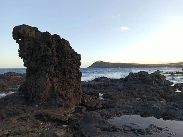 美丽的岩石海滩和周围的风景映衬着明亮的蓝天 — 图库照片