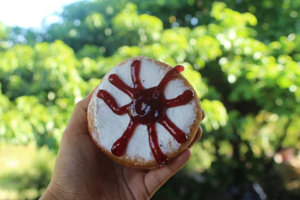 Bulanık Arka Planda Çikolatalı Çörek Tutan Bir — Stok fotoğraf