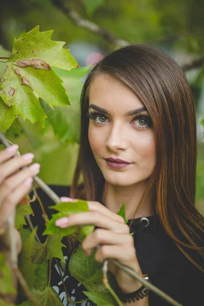 Uma Jovem Morena Caucasiana Posando Perto Uma Árvore Com Folhas — Fotografia de Stock