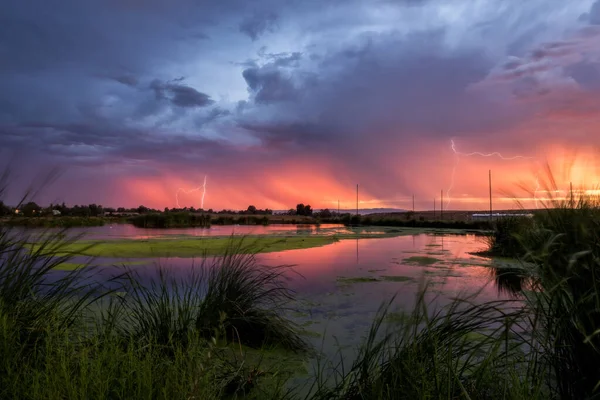 Ett Landskap Sjö Med Blixten Reflekterar Över Det Solnedgången Stormig — Stockfoto