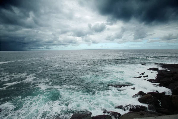 Kasvetli Bir Gökyüzünün Altında Kayalık Bir Sahile Vuran Güçlü Dalgaların — Stok fotoğraf