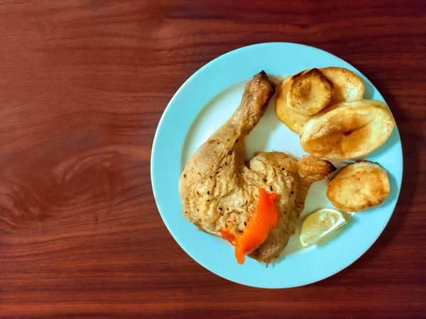 木製の背景にプレート上の伝統的な調理鶏の足とローストスペインのジャガイモのオーバーヘッドショット — ストック写真