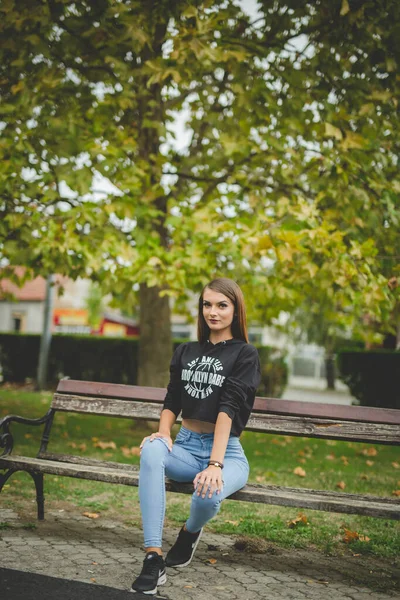 Eine Attraktive Junge Kaukasische Frau Sitzt Auf Einer Bank Und — Stockfoto