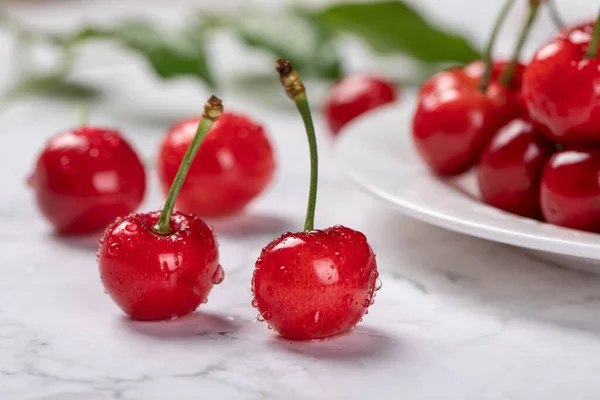 stock image A closeup shot of red cherries with droplets on a tb