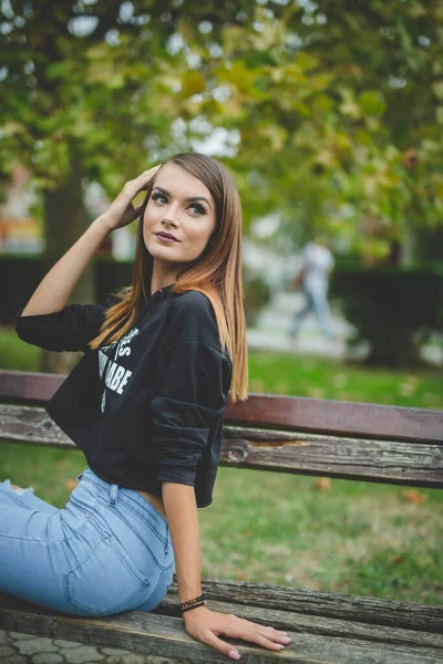 Eine Attraktive Junge Kaukasische Frau Sitzt Auf Einer Bank Und — Stockfoto