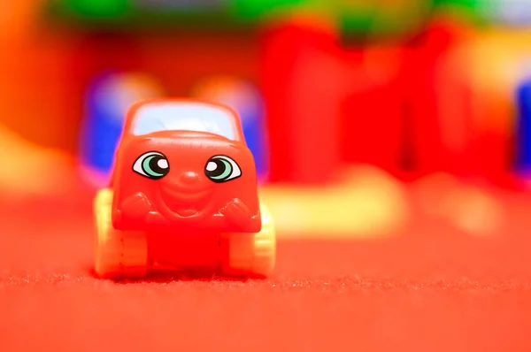 Πλαστικό Πολύχρωμο Παιχνίδι Αυτοκίνητο Στο Κόκκινο Χαλί — Φωτογραφία Αρχείου