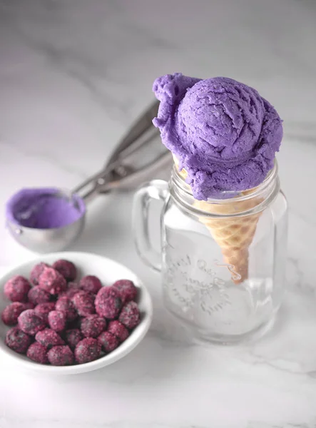 プレート上の果実とガラスカップに紫色のアイスクリームコーンの垂直ショット — ストック写真