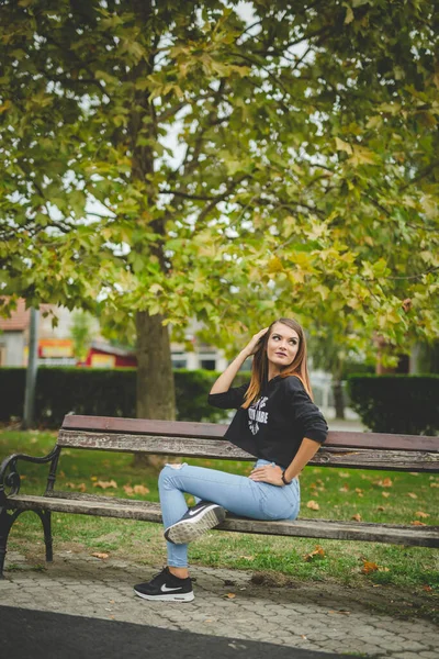 Een Aantrekkelijke Jonge Blanke Vrouw Zittend Een Bank Poserend Een — Stockfoto