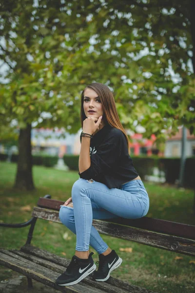 Een Aantrekkelijke Jonge Blanke Vrouw Zittend Een Bank Poserend Een — Stockfoto