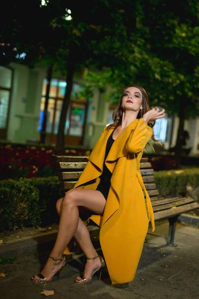 Sarı Ceketli Çekici Bir Beyaz Kadın Bankta Oturuyor Akşamları Parkta — Stok fotoğraf