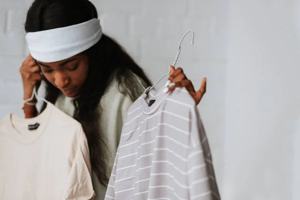 Uma Bela Jovem Africana Segurando Cabides Com Duas Camisetas Casuais — Fotografia de Stock