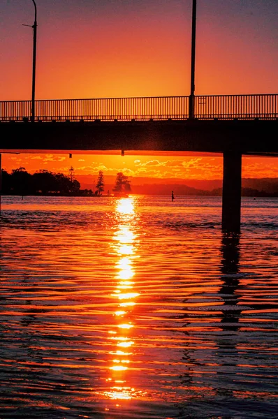 Uma Foto Hipnotizante Pôr Sol Laranja Sobre Rio Uma Ponte — Fotografia de Stock