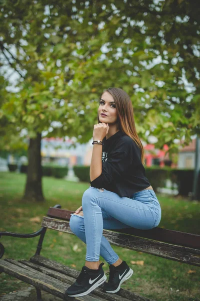 Een Aantrekkelijke Jonge Blanke Vrouw Zittend Een Bank Poserend Een — Stockfoto