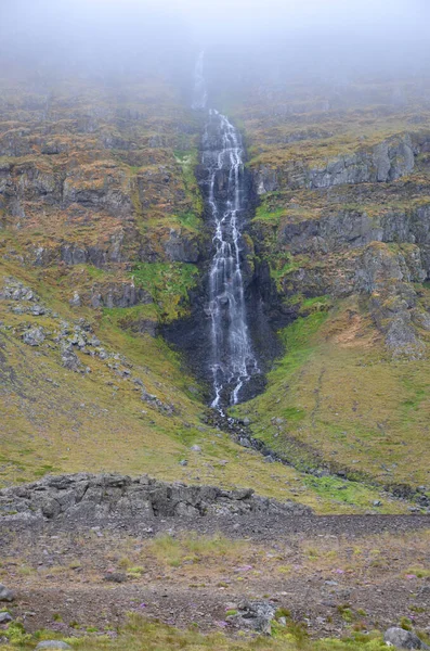 Ein Atemberaubender Blick Auf Einen Hohen Dünnen Wasserfall Zwischen Grasbewachsenen — Stockfoto