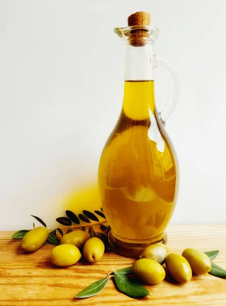 Een Fles Olijfolie Groene Olijven Met Bladeren Een Houten Tafel — Stockfoto