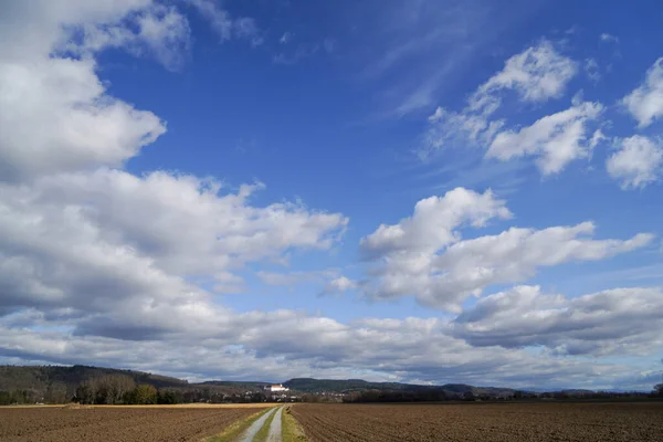 Krásný Záběr Zemědělských Polí Silnicí Uprostřed Pod Zamračenou Modrou Oblohou — Stock fotografie