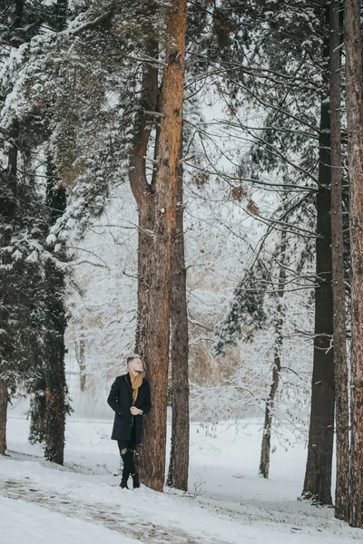 Handsome Young Man Black Winter Outfit Brown Scarf Leaning Forest — стоковое фото