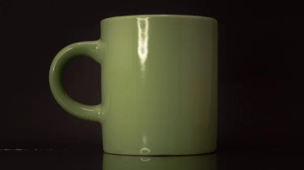 Plan Latéral Une Tasse Verte Isolée Sur Fond Noir — Photo