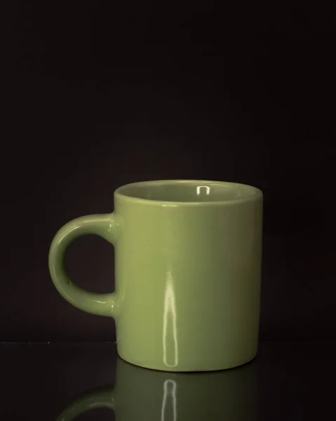 在黑色背景上隔离的绿色杯子的垂直前照 — 图库照片