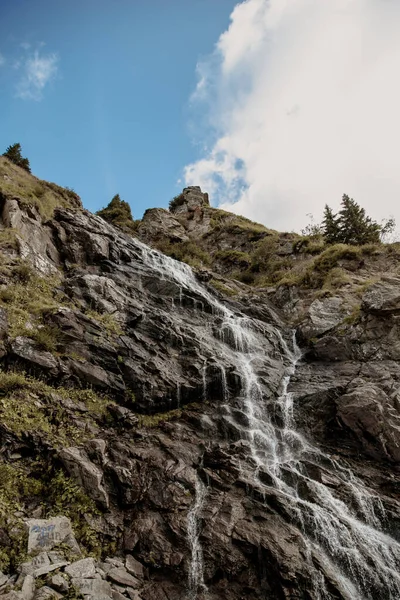 Ein Wasserfall Umgeben Von Grünen Felsen Unter Dem Sonnenlicht Und — Stockfoto