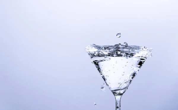 Focus Selettivo Una Spruzzata Acqua Bicchiere Martini Chiaro Fondo Bianco — Foto Stock