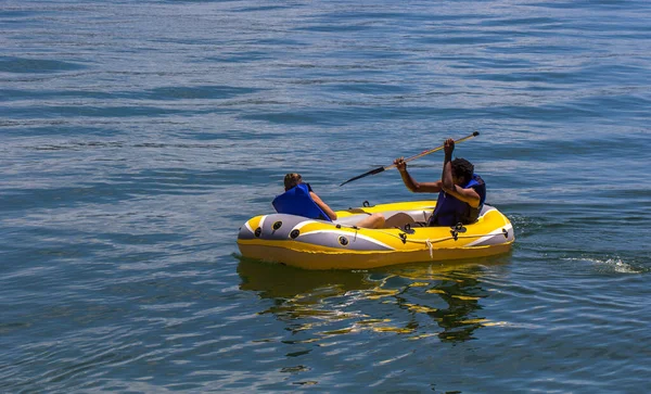 两个男人坐在黄色充气皮划艇上 — 图库照片