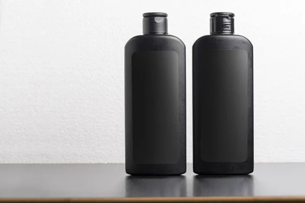 两个黑色的头发洗发水瓶在浅灰的背景 可编辑的模型系列模板为您的设计准备 — 图库照片