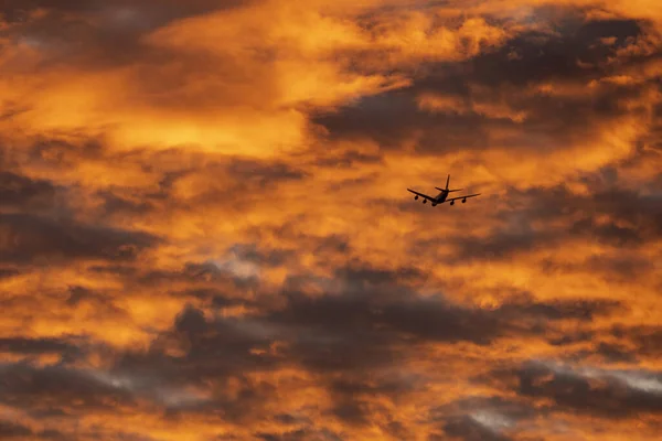 Una Vista Fascinante Avión Volando Contra Cielo Nublado Naranja Durante — Foto de Stock