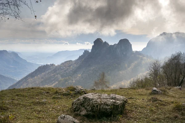 Krajobraz Skał Pagórkowatym Terenie Tłem Gór Pod Ponurym Niebem — Zdjęcie stockowe