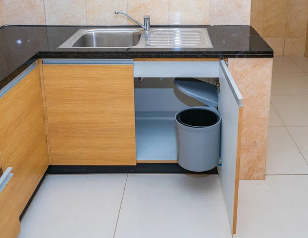 Крупный План Открытого Кухонного Шкафа Пластиковым Мусорным Баком — стоковое фото