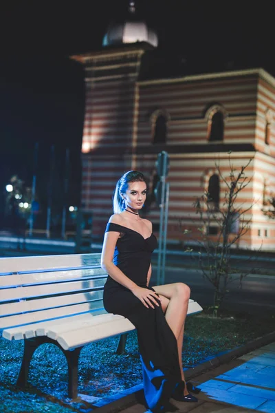 Uma Jovem Bonita Vestindo Vestido Preto Elegante Está Sentada Banco — Fotografia de Stock