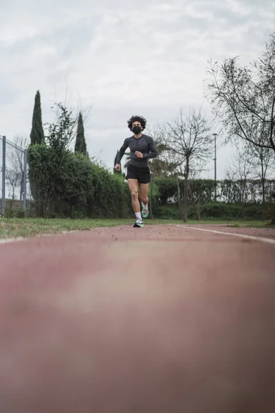 Yüzü Maskeli Bir Erkek Sporcunun Sabah Parkta Koşuşunun Yüzeysel Odağı — Stok fotoğraf