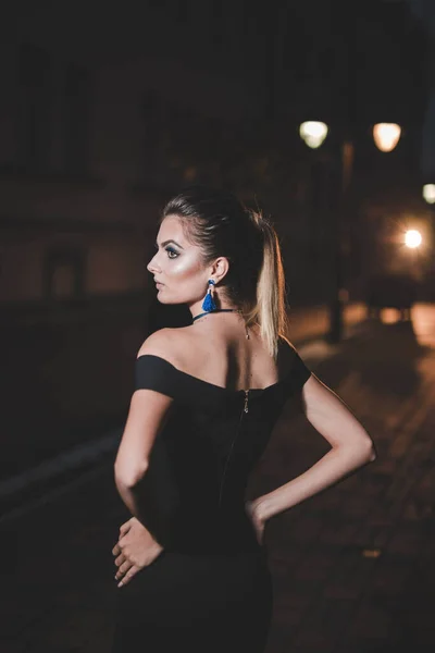 一张波斯尼亚妇女穿着雅致的黑色晚礼服站在室外的垂直照片 — 图库照片