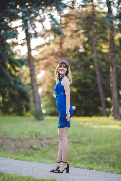 Вертикальний Постріл Кавказької Дівчини Синьому Платті Каблуках Стоїть Парку Посміхаючись — стокове фото