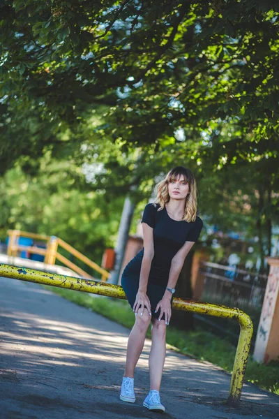 Een Jonge Vrouw Met Casual Kleding Sneakers Zit Metalen Paal — Stockfoto