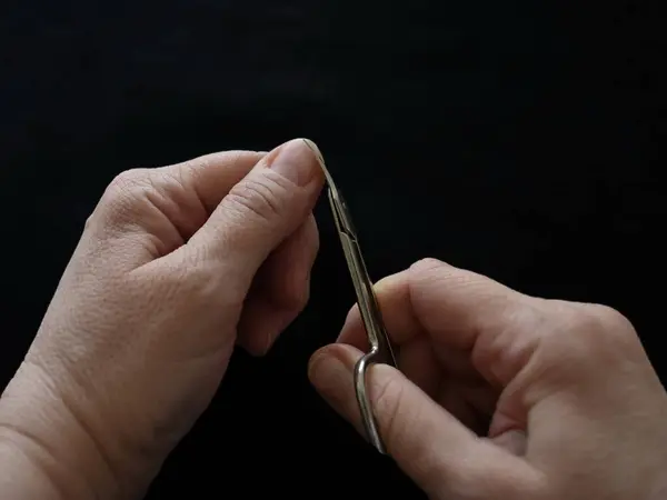 Tiro Seletivo Nas Mãos Uma Fêmea Cortando Suas Unhas Com — Fotografia de Stock