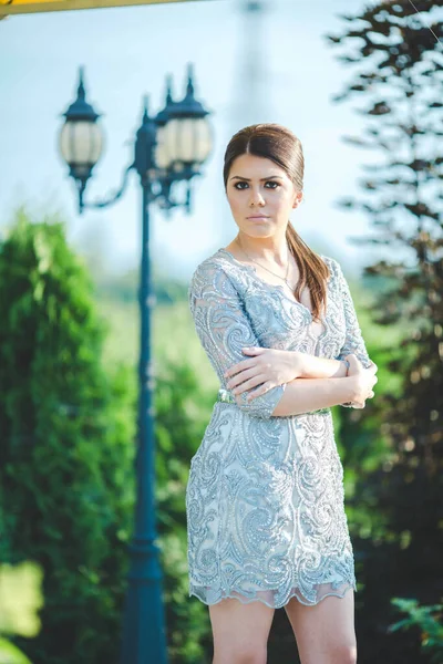 美しい庭にポーズをとった素敵なドレスを着た魅力的な女性の垂直ショット — ストック写真