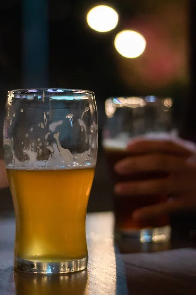 Disparo Vertical Vaso Cerveza Sobre Mesa Con Una Mano Sosteniendo — Foto de Stock