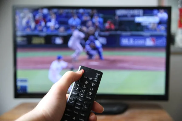 Hand Holding Remote Controller Blurred Screen Baseball Broadcast — Stock Photo, Image