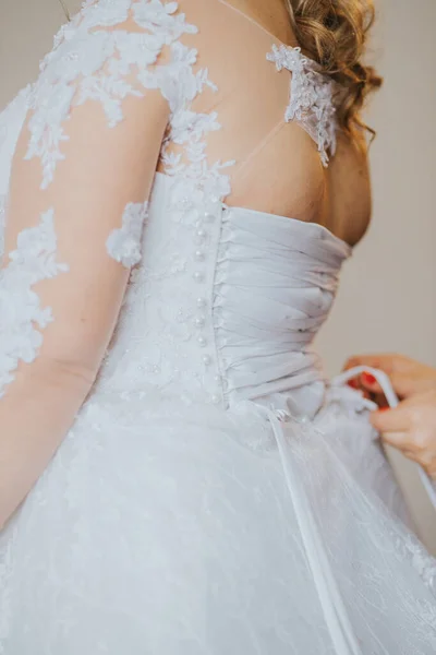 花嫁を助ける花嫁介添人の手のクローズアップ彼女の繊細なドレス — ストック写真