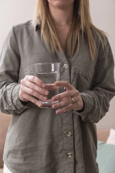 水のガラス 水の完全な結晶ガラスを保持する女性の手のクローズアップ 垂直写真 — ストック写真