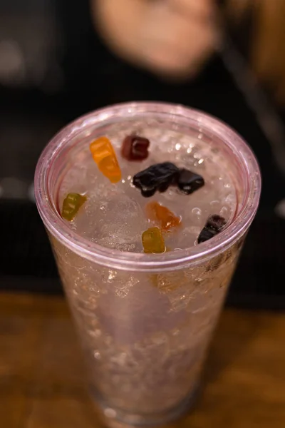 A vertical shot of an icy drinks with gummy bears on top