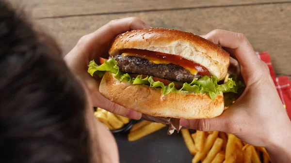 Zbliżenie Ujęcie Osoby Jedzącej Pysznego Cheeseburgera Frytkami Talerzu — Zdjęcie stockowe