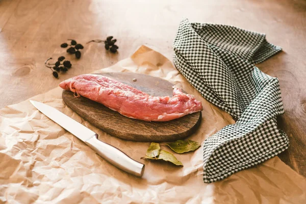 まな板の上に生の豚ヒレ肉を盛り付け 調味料をテーブルの上に乗せて食べる — ストック写真