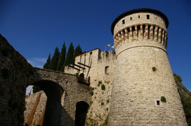 A low-angle shot of the castle of Brescia against the blue sky clipart