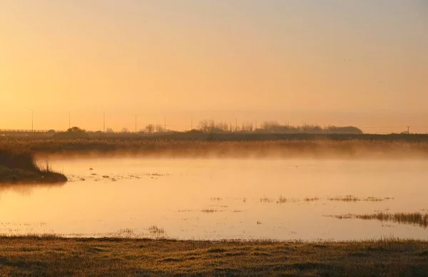 Krásný Výhled Jezero Obklopené Poli Trávy Kopců Při Západu Slunce — Stock fotografie