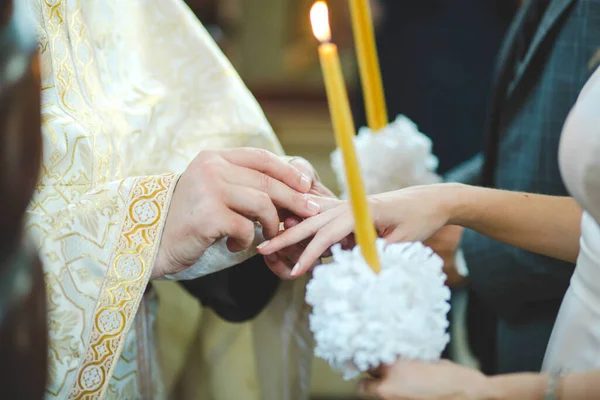 牧师将戒指戴在她手上时 新娘拿着蜡烛的特写镜头 — 图库照片
