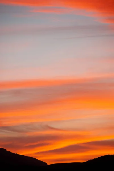 モロッコの山々のシルエットの上の日没で黄金とピンクの雲の息をのむような景色 — ストック写真